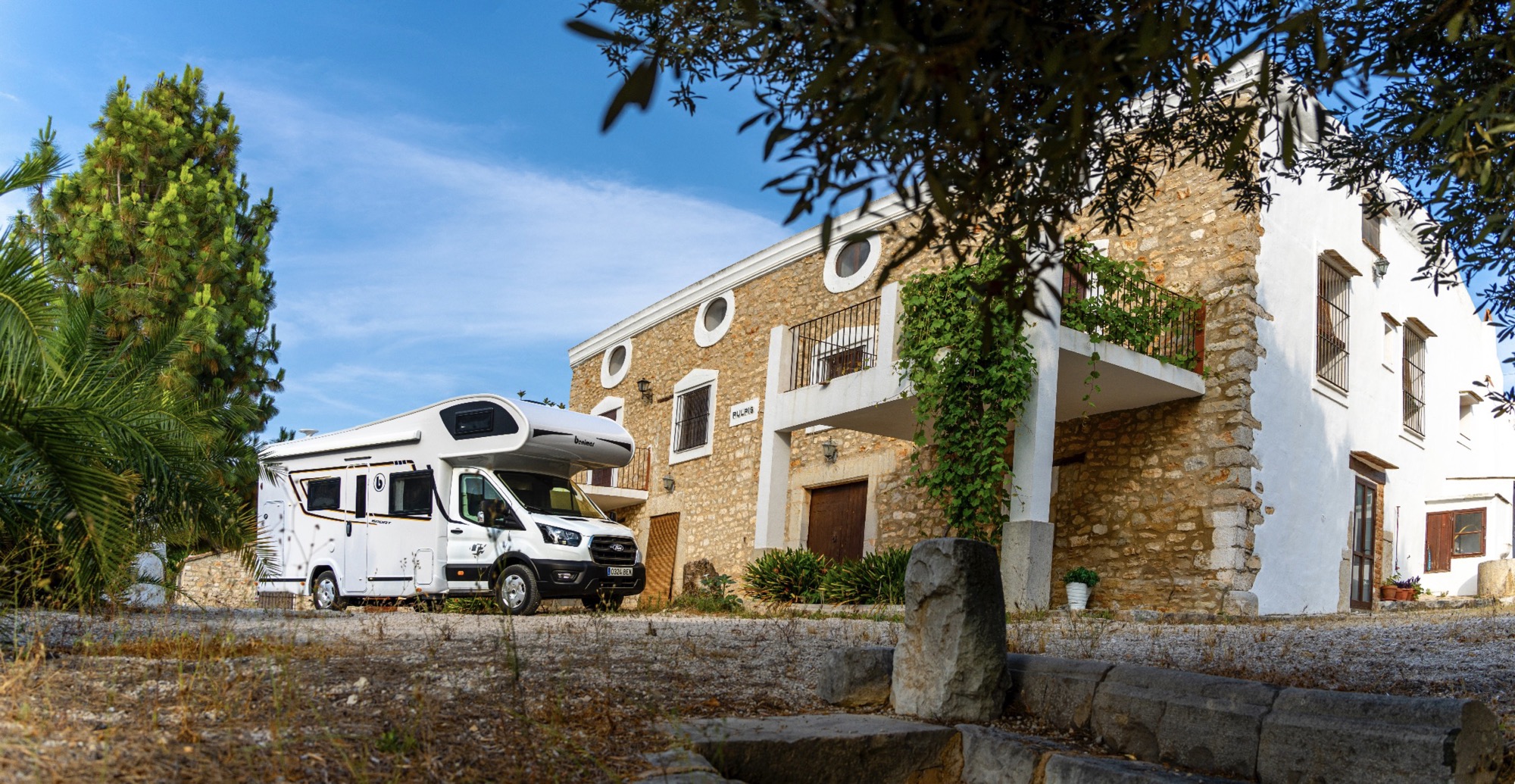 Autocaravana Benimar Sport UP estacionada junto a una casa de campo
